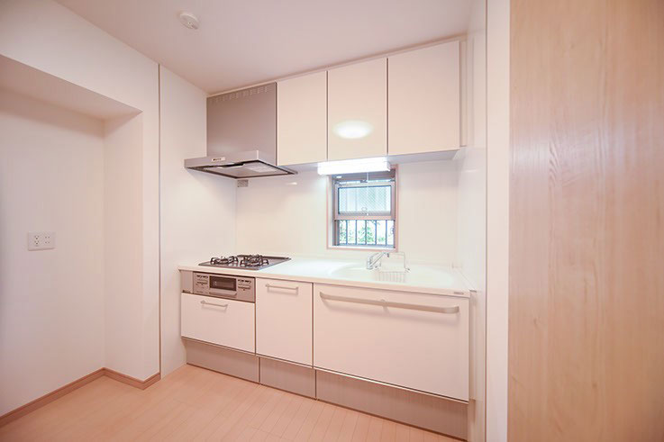 リフォームで施工された、清潔感のある白色の壁付キッチンの写真